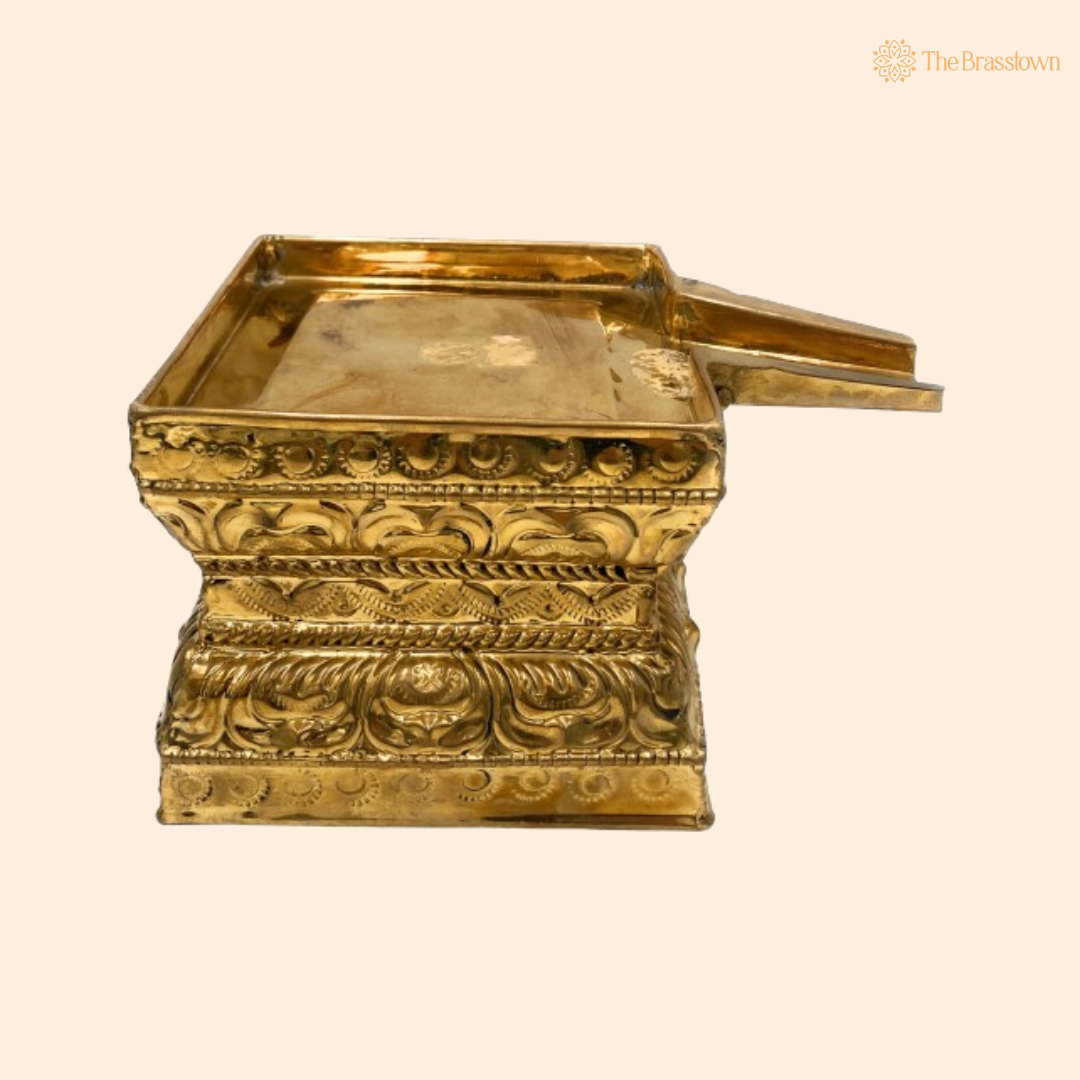 A gold-colored brass Havan Kund with ornate carvings, designed for sacred rituals.