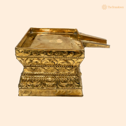 A gold-colored brass Havan Kund with ornate carvings, designed for sacred rituals.